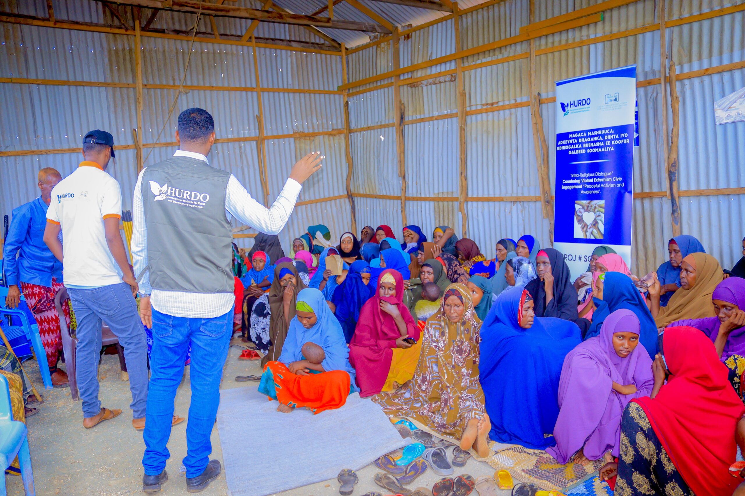 HURDO staff speaking to women seated in a community session