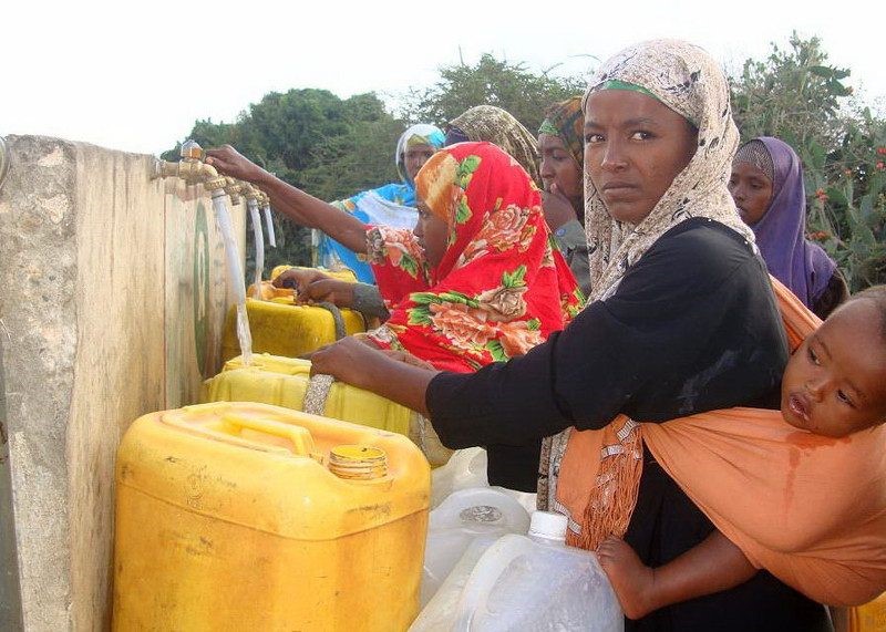 Women and children collecting water at a tap stand